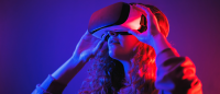 Young girl in virtual reality glasses with blue and red illumination in the room